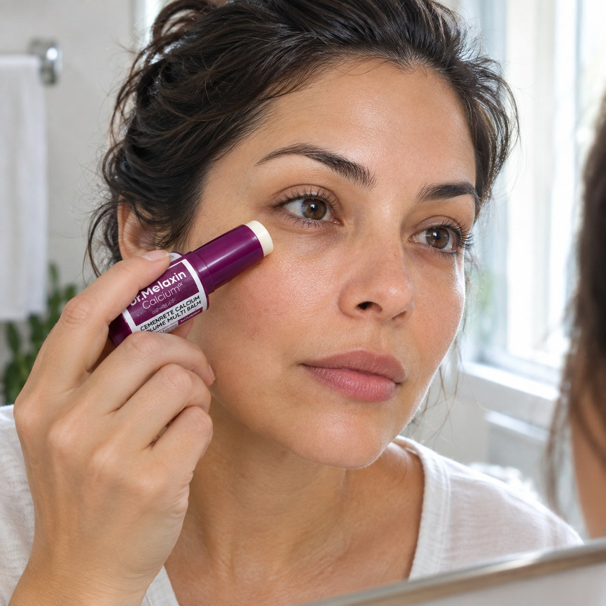Mujer aplicando el Multi Balm bajo el ojo